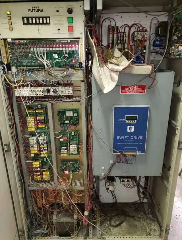 Open elevator controller cabinet photographed during an equipment audit